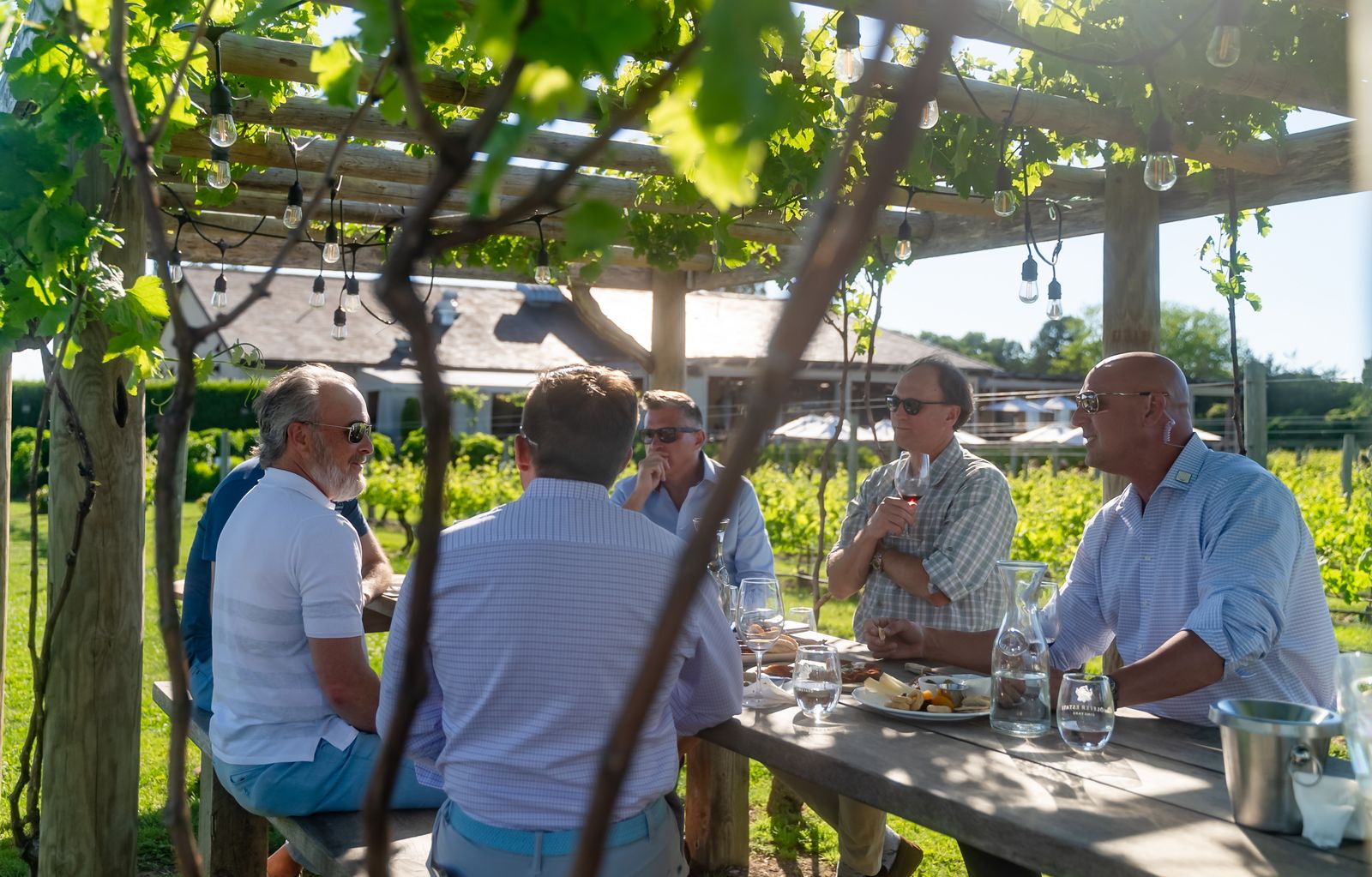 Guests at a long table, a CADRE team member present at the edge of the group